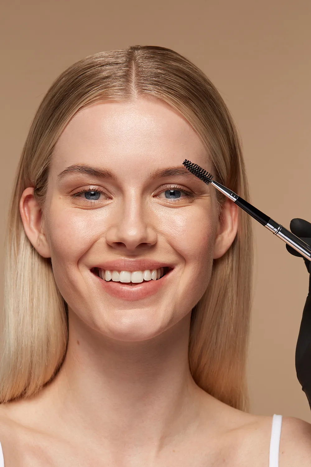 Anwendung eines Browlifts, auch bekannt als Brauenlaminierung, mit einem Bürstchen zur Formung und Hervorhebung der Augenbrauen, dargestellt mit Produkten der Marke Augenmanufaktur